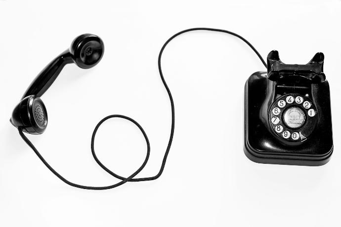 photo of black rotary phone against white background